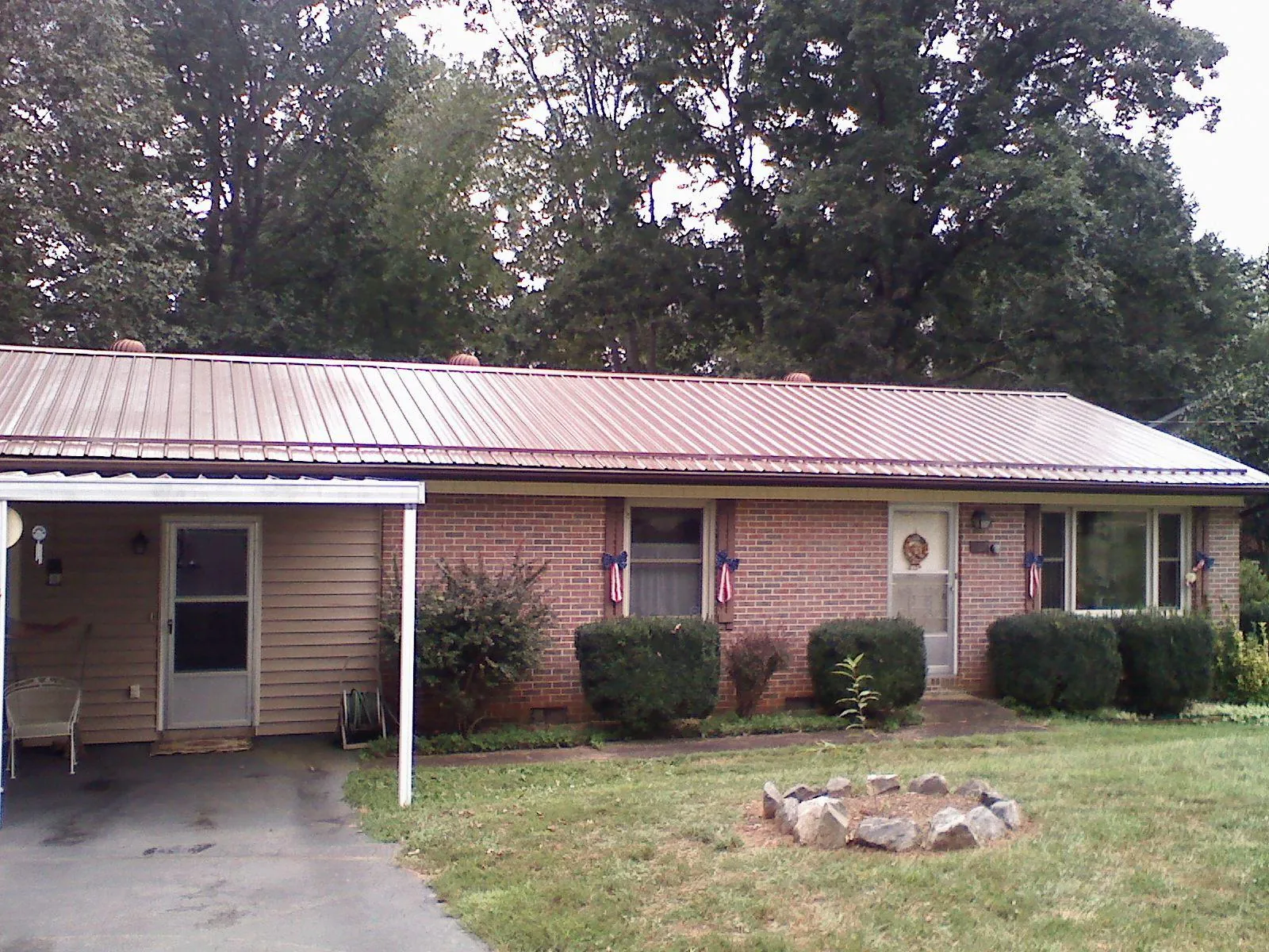 Bronze metal roof and carport on a brick ranch home — Roof Repair work by our crew in Lockhart