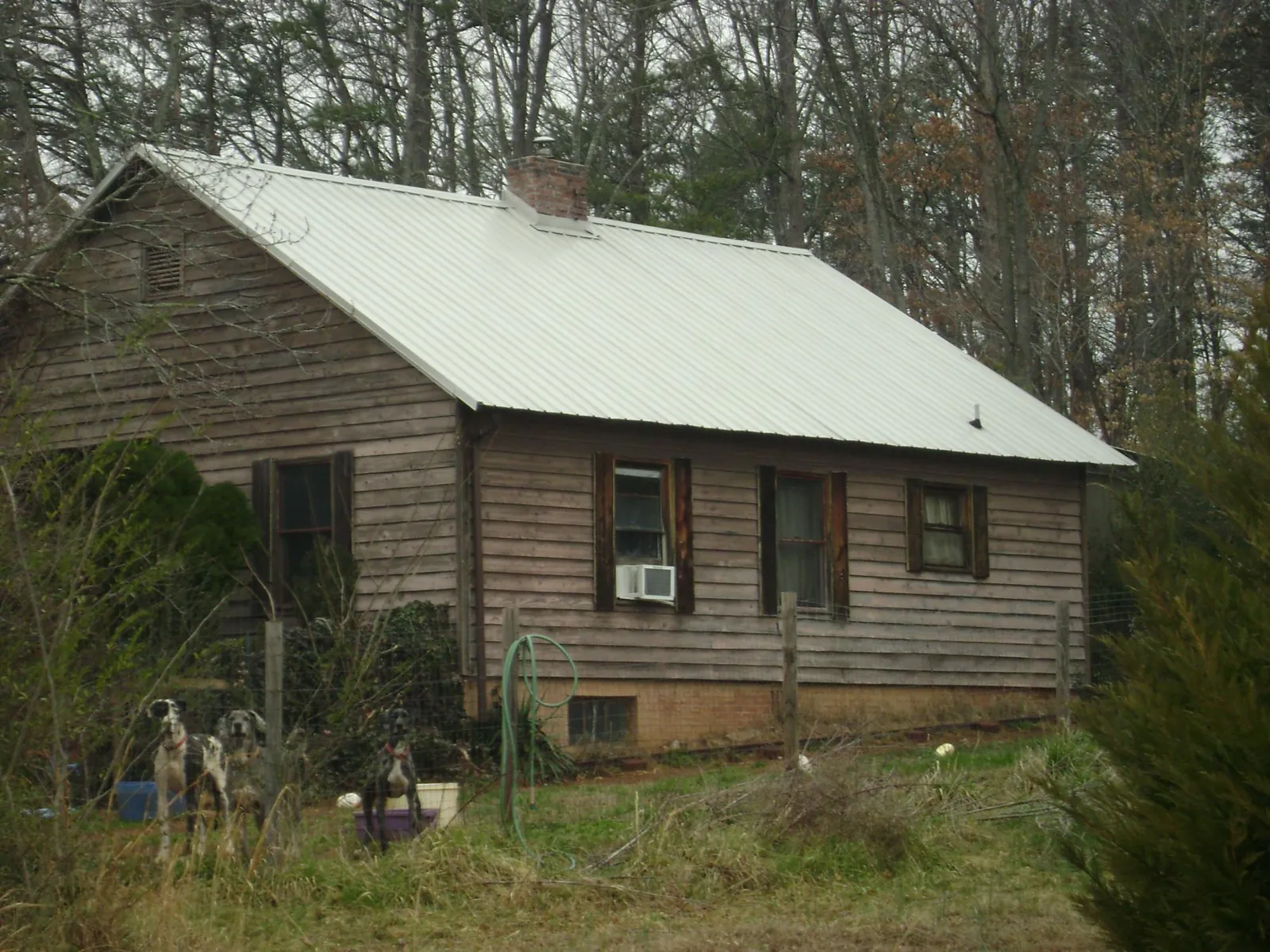 White metal roof on an old wood sided farmhouse, from a Metal Roof Installation job in Lockhart